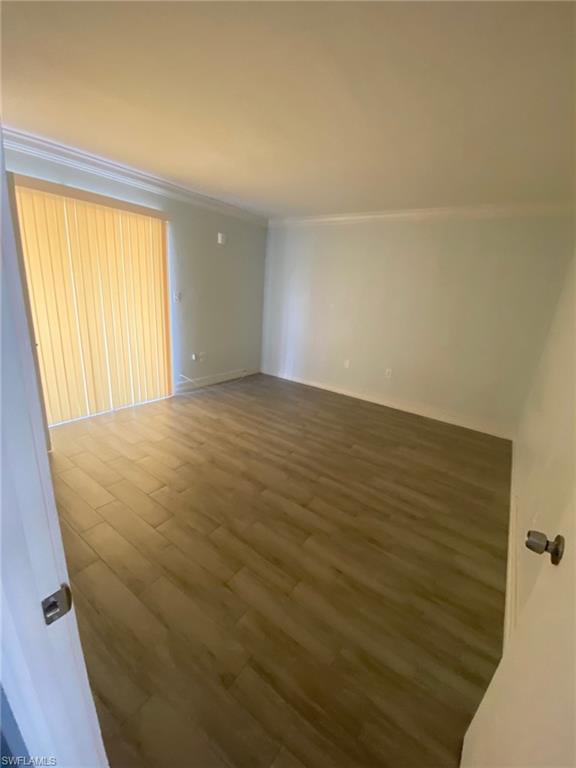 Unfurnished room featuring wood finished floors and ornamental molding