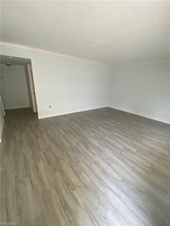 Unfurnished room with wood finished floors and ornamental molding