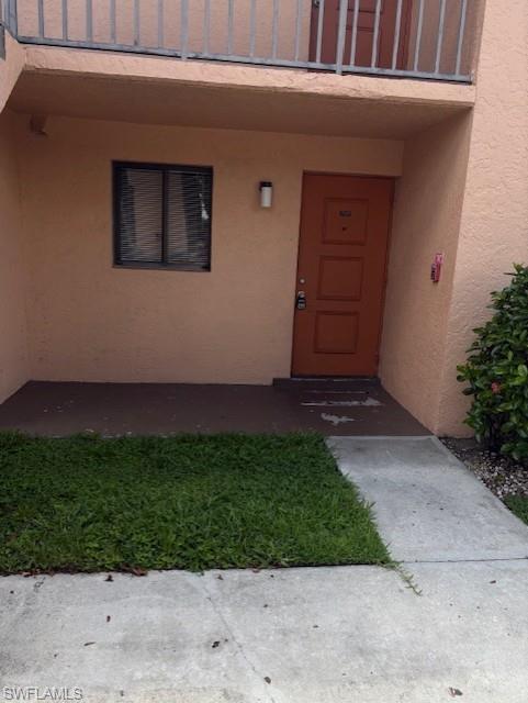 View of exterior entry featuring stucco siding