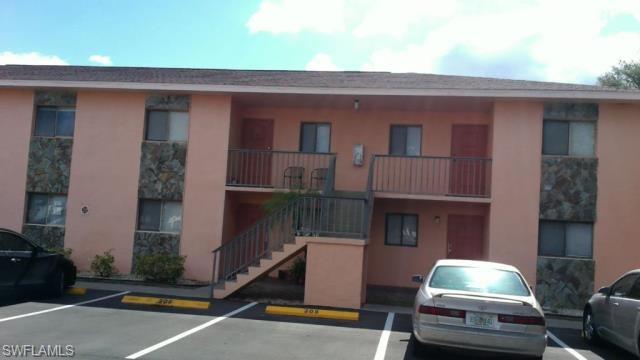 View of building exterior featuring uncovered parking and stairs