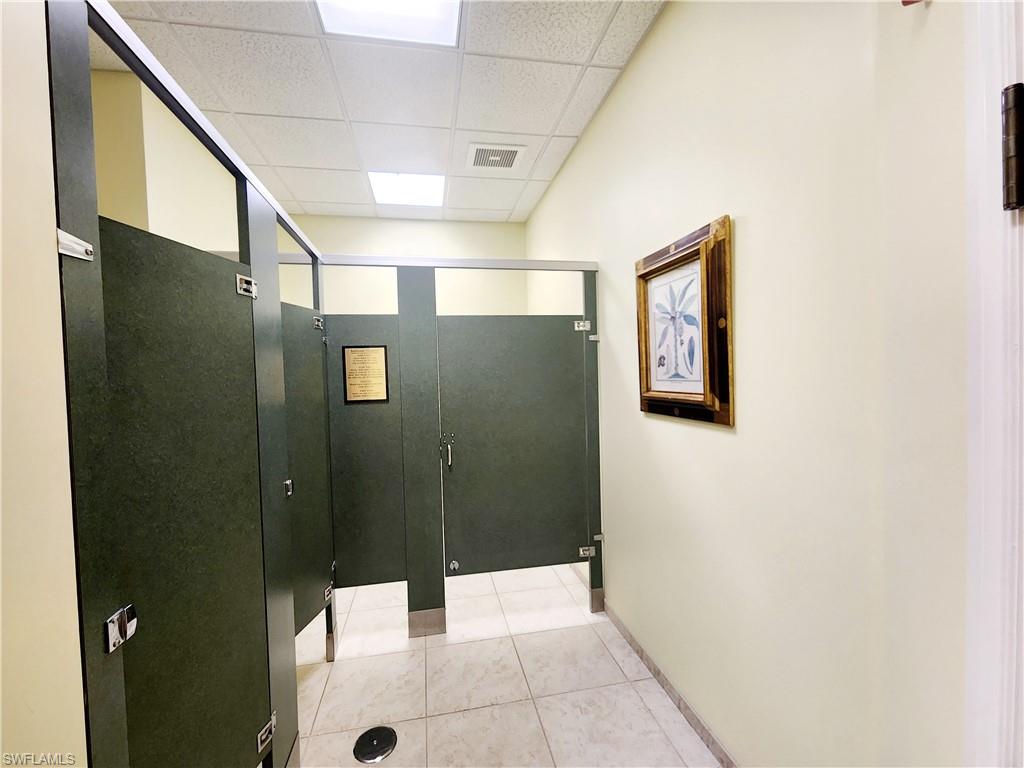 Hallway featuring a paneled ceiling and light tile patterned floors
