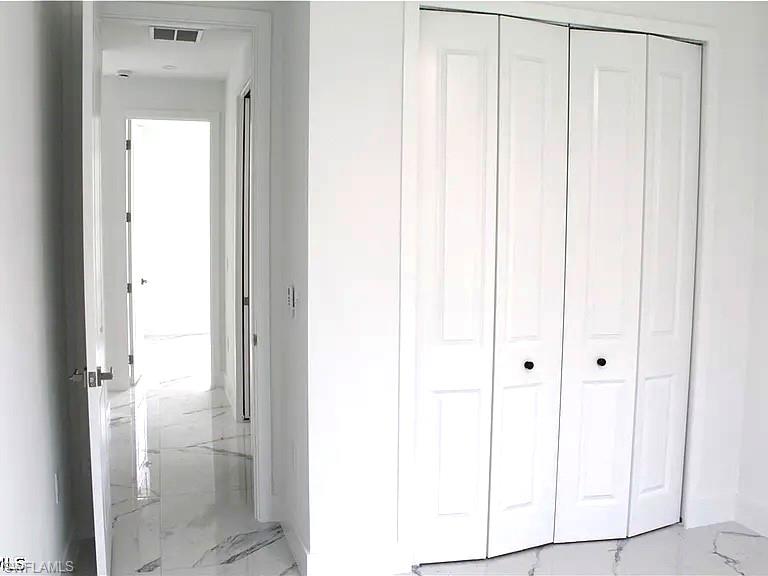 Hallway featuring crisp white walls and white baseboards