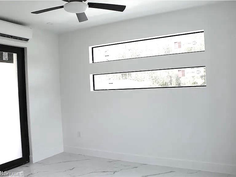 Room featuring two horizontal transom windows, a large black-framed door, a ceiling fan, and an air conditioning unit