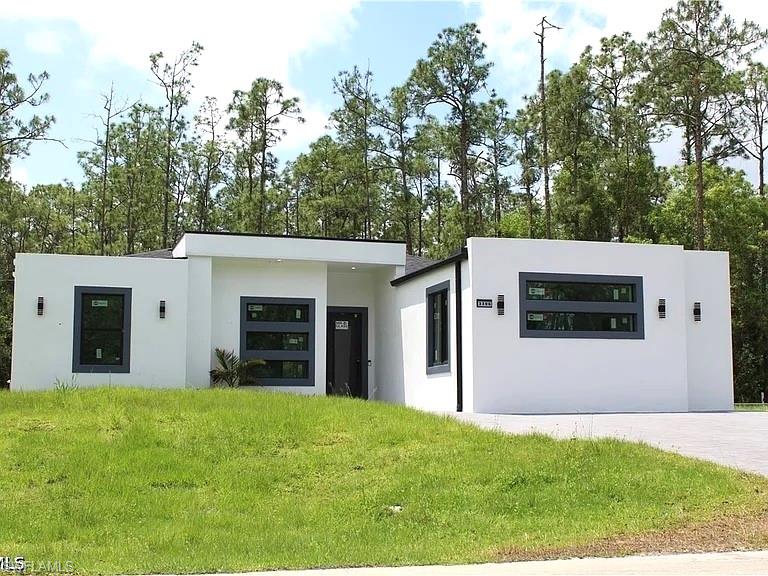 Contemporary facade featuring a white stucco exterior, black-framed windows, and modern exterior lighting fixtures