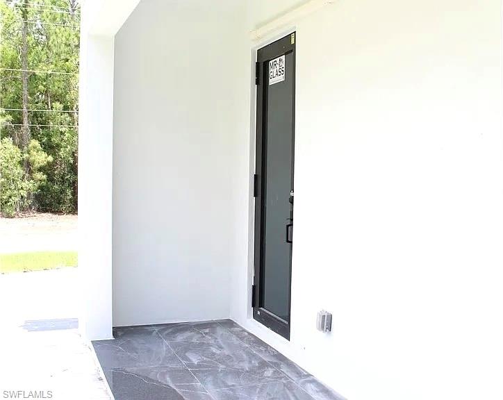 In-Law entry featuring modern gray tile flooring and a sleek black door frame