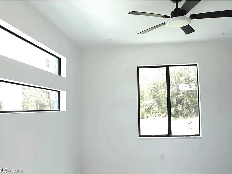 Contemporary interior with clean white walls and a modern black ceiling fan