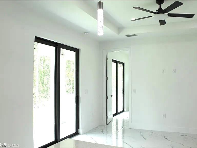 Bright interior space featuring large sliding glass doors, white walls, and polished white tile flooring