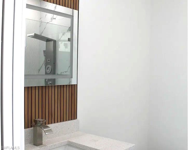 Vanity area featuring a sleek rectangular sink, brushed nickel faucet, and a quartz-finish countertop