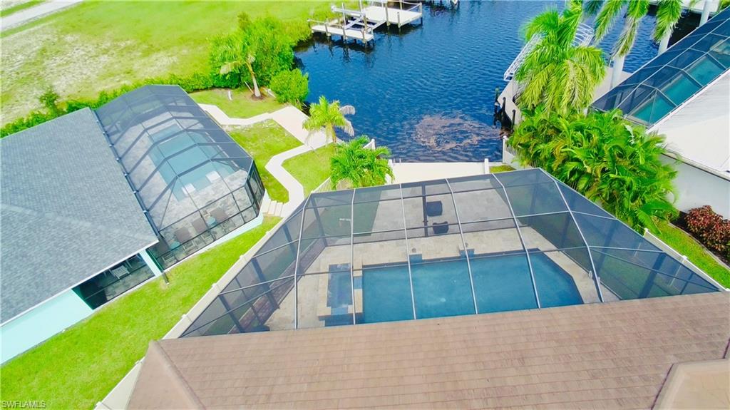Drone / aerial view of a nearby body of water and a pool area