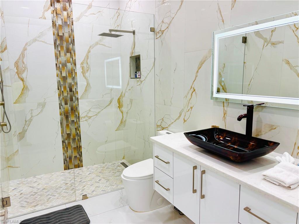 Bathroom with a marble finish shower and vanity