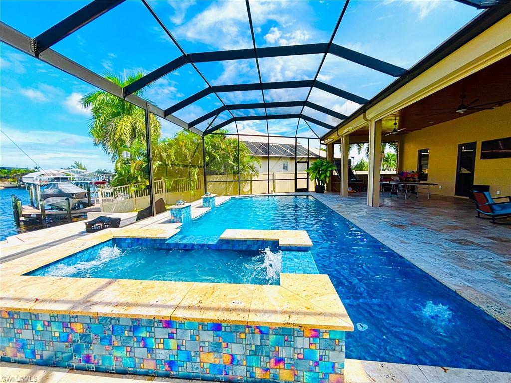 Integrated pool / hot tub featuring a sunroom, a patio area, glass enclosure, and outdoor dining space
