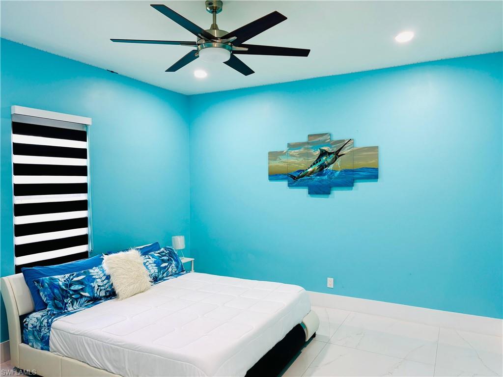 Bedroom featuring a ceiling fan, recessed lighting, and marble finish flooring