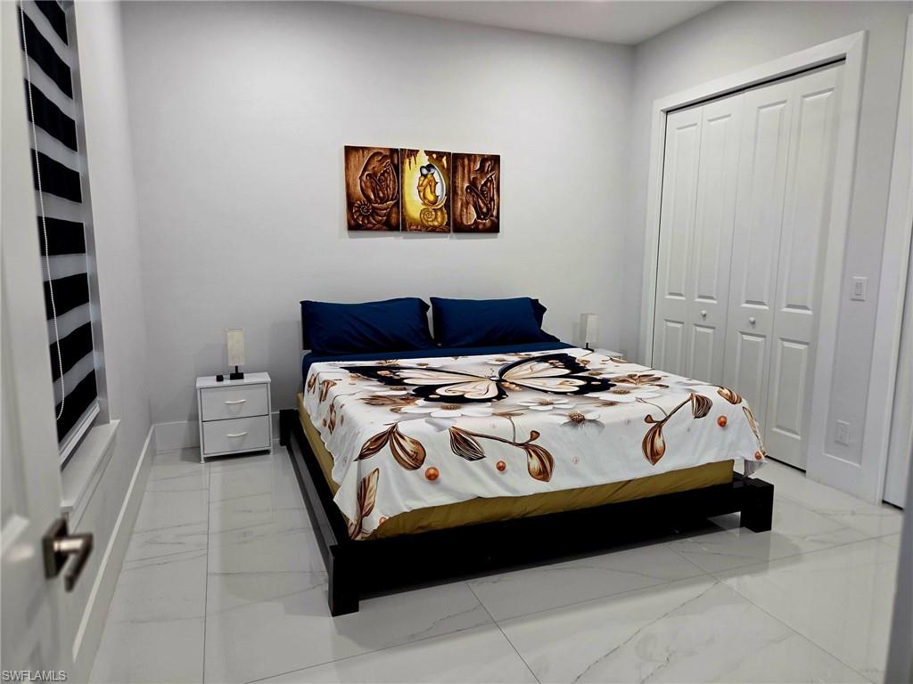Bedroom featuring a closet and light marble finish flooring