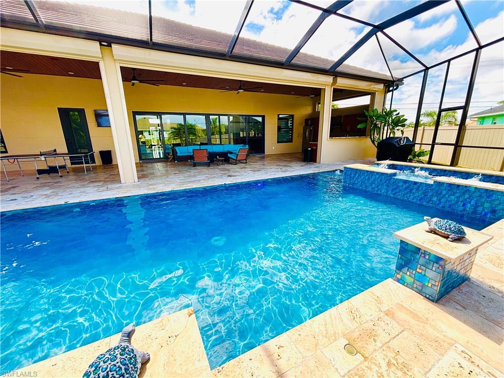 Integrated pool / spa featuring a sunroom, a patio, a lanai, and an outdoor living / dining area