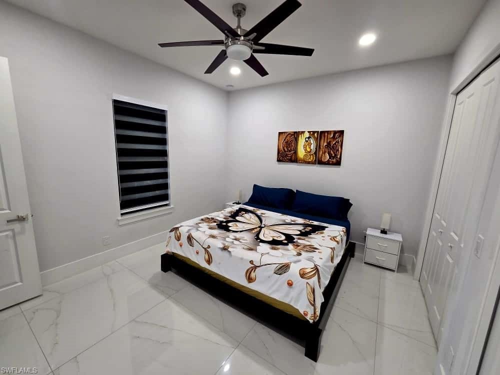 Bedroom with a closet, recessed lighting, ceiling fan, and light marble finish floors