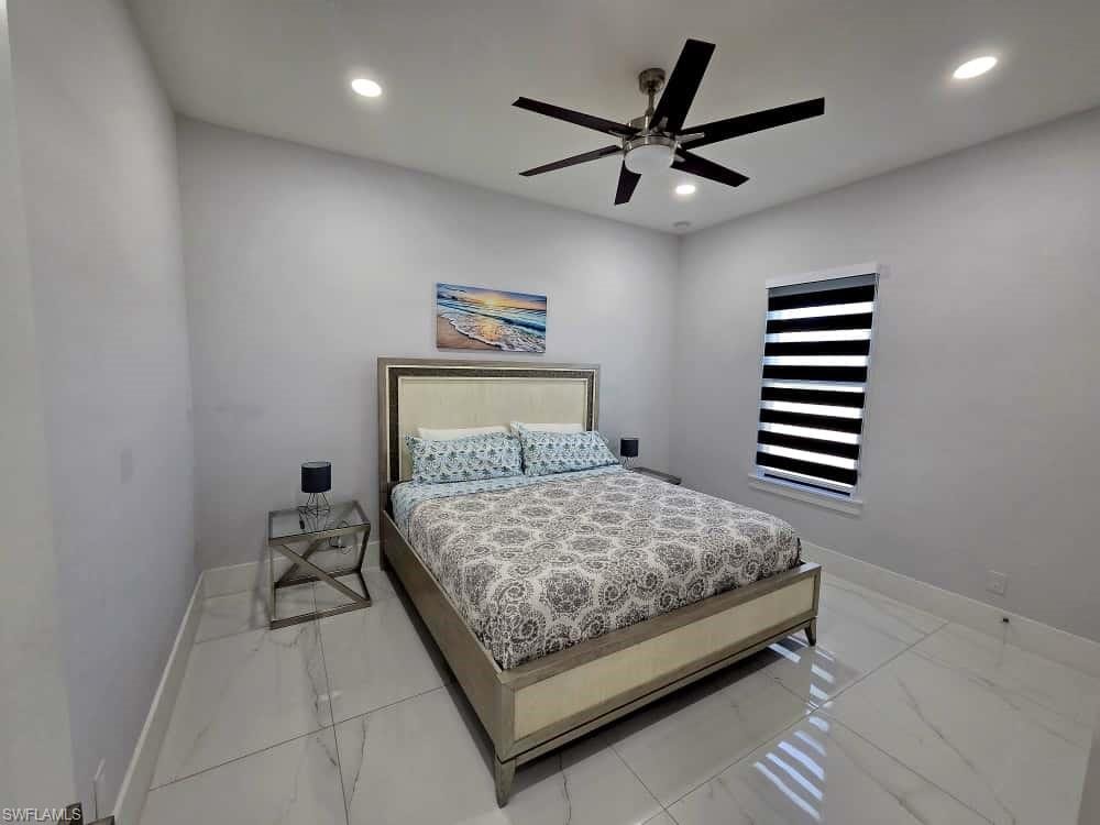 Bedroom with ceiling fan, recessed lighting, and light marble finish flooring