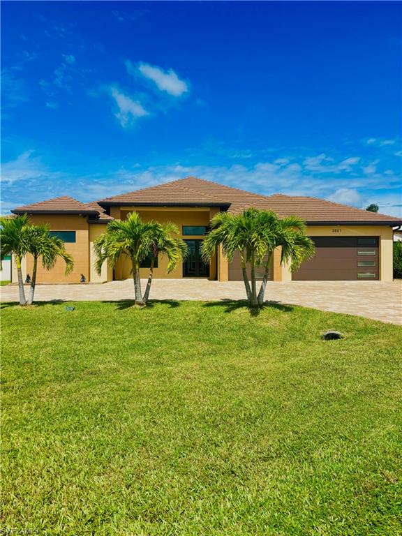 View of front of home featuring a front yard, stucco siding, driveway, and a garage