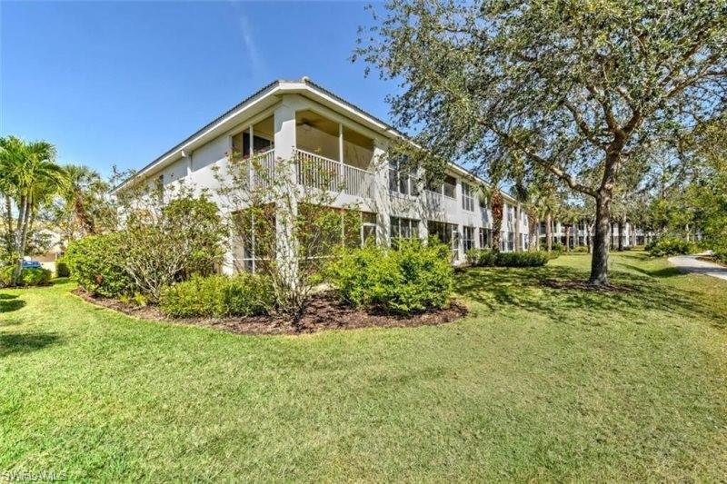 View of property exterior featuring a balcony and a yard