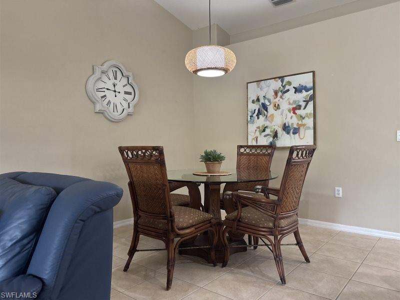 Dining space with baseboards and light tile patterned floors