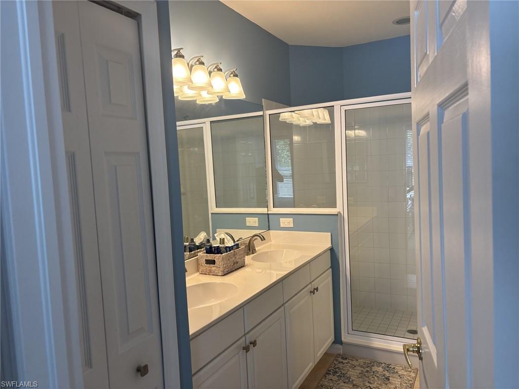Bathroom with double vanity and a stall shower