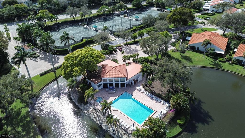 Drone / aerial view of a pool area and a nearby body of water