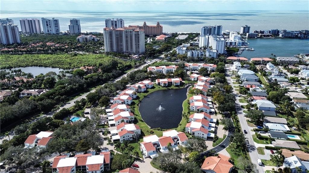 Aerial view of property and surrounding area featuring a large body of water and nearby suburban area