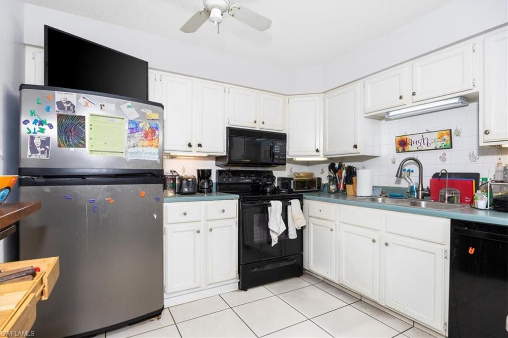 Kitchen with black appliances, white cabinets, ceiling fan, light tile patterned flooring, and backsplash