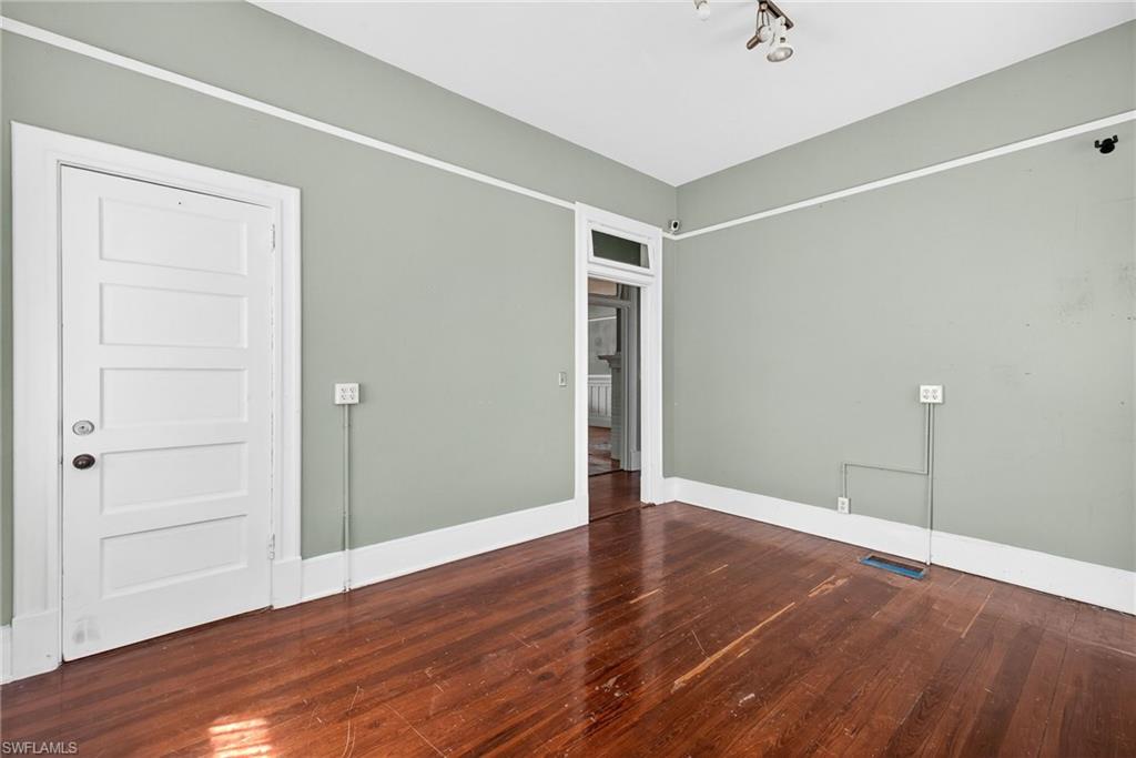 Empty room featuring dark wood-style floors and baseboards