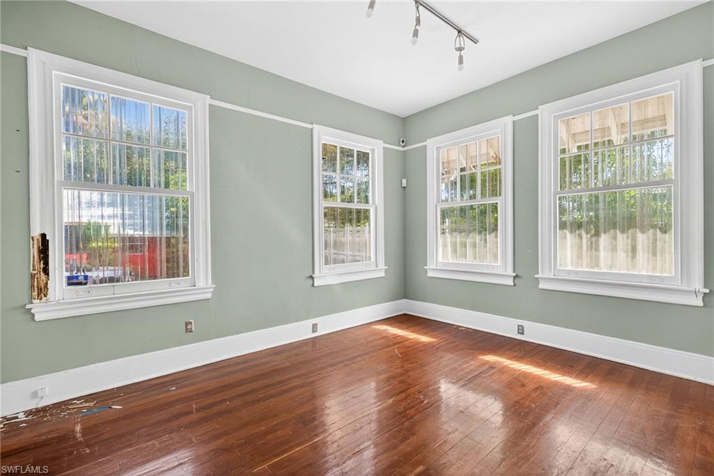 Spare room featuring wood-type flooring and rail lighting