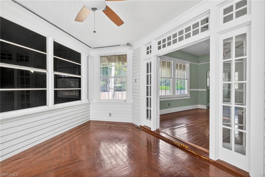 Unfurnished sunroom featuring hardwood / wood-style flooring and wooden walls