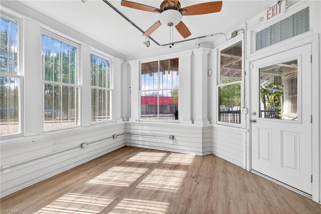 Unfurnished sunroom featuring a ceiling fan