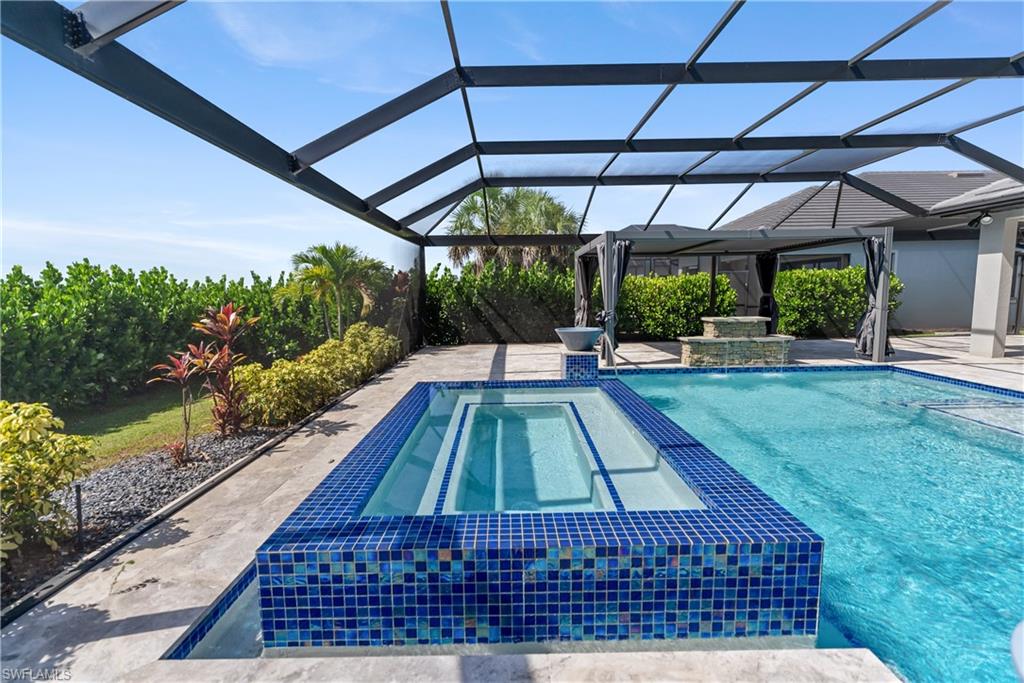Integrated pool / spa featuring a screen enclosure and a lake view