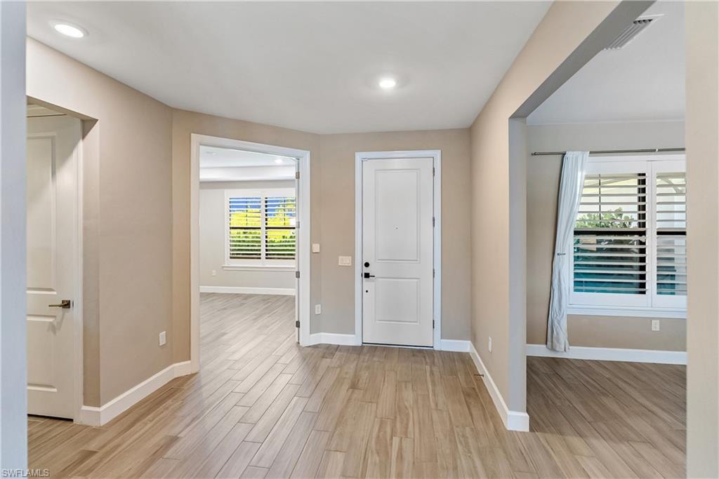 Entrance foyer with light wood-style tile flooring and baseboards