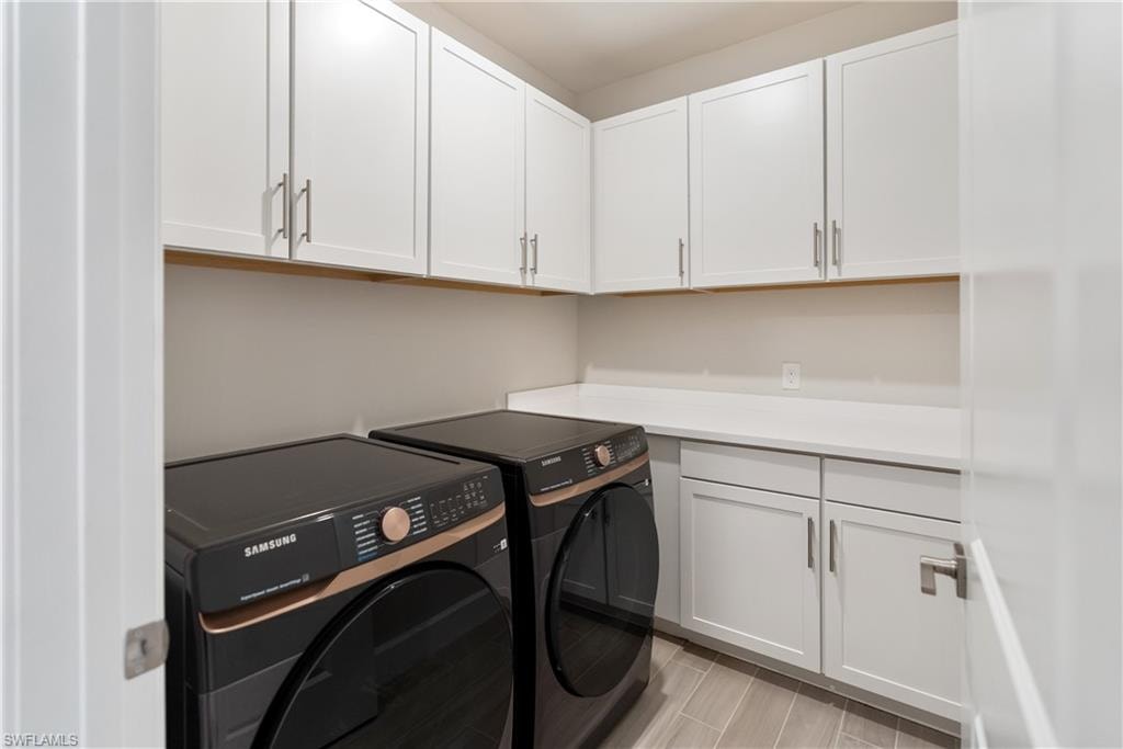 Laundry room featuring washing machine and dryer and cabinet space