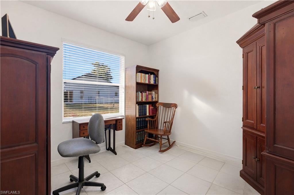 Office area with a ceiling fan and light tile patterned floors