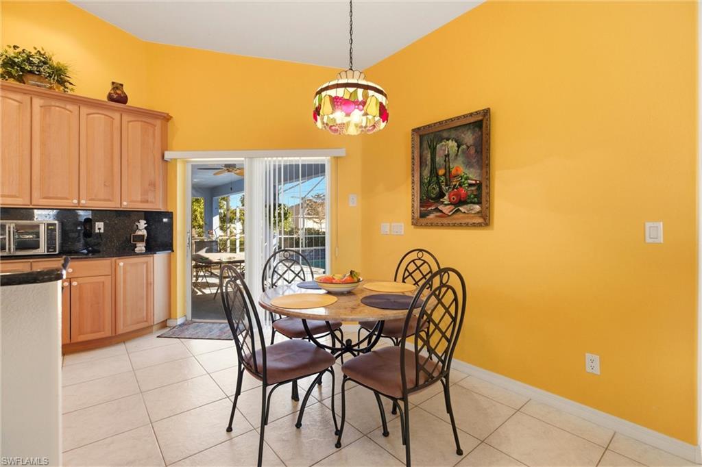 Dining space featuring light tile patterned floors, suspended lighting, and ceiling fan