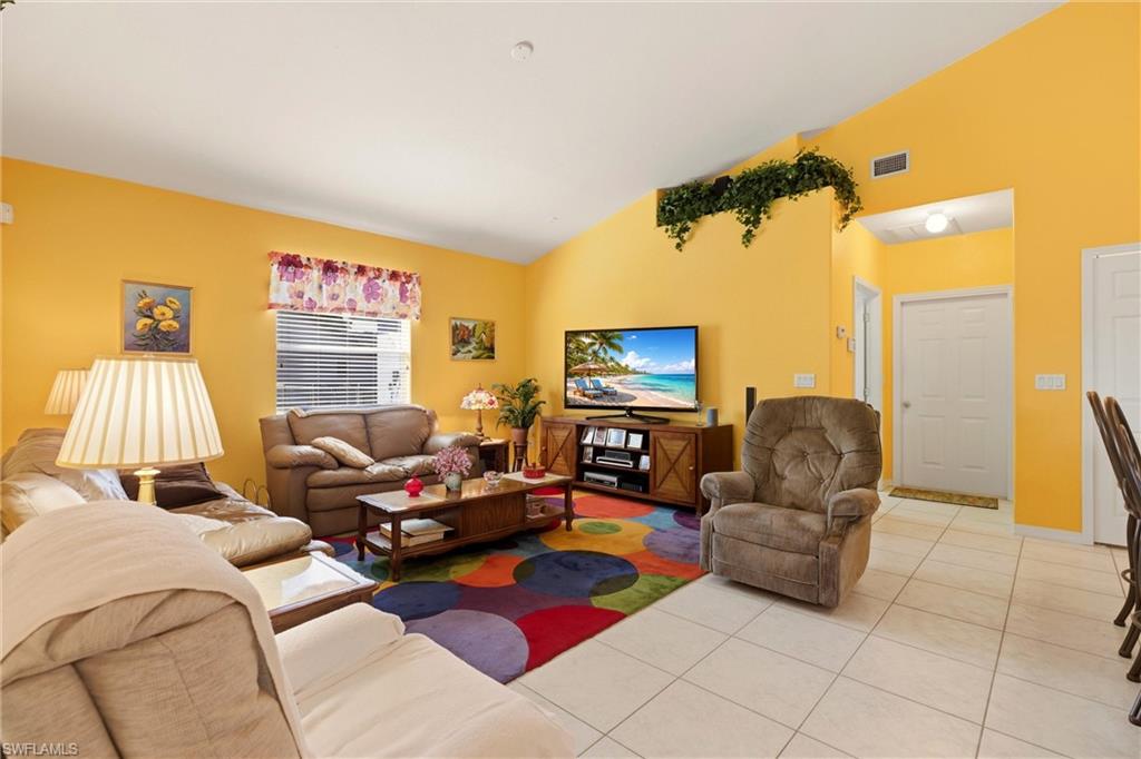 Living area featuring vaulted ceiling and light tile patterned flooring