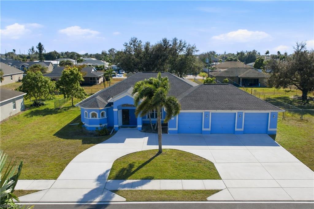 View of front of property featuring a front lawn, driveway, a garage, a shingled roof, and a residential view