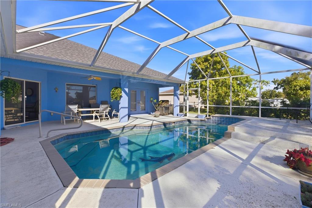Outdoor pool featuring glass enclosure, a sunroom, a patio, french doors, and outdoor dining space