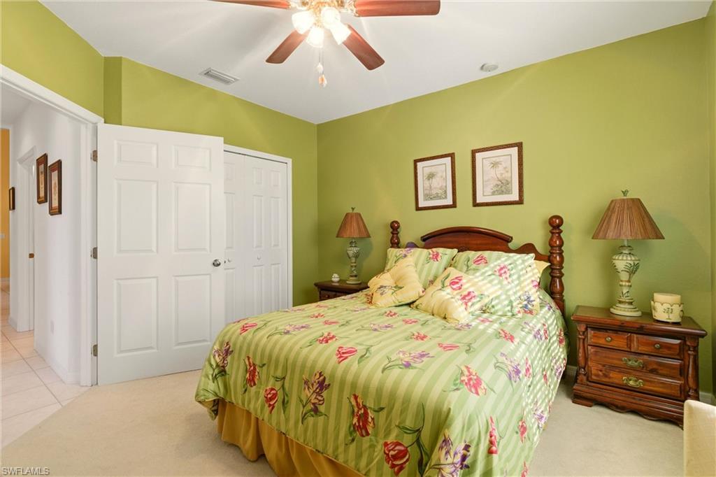Bedroom with a closet, a ceiling fan, and light carpet