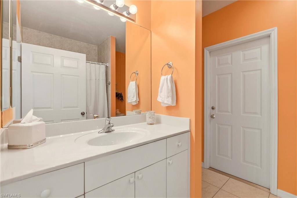 Full bathroom with vanity, a shower with shower curtain, and light tile patterned floors