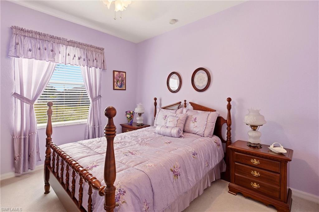 Bedroom with light colored carpet and baseboards