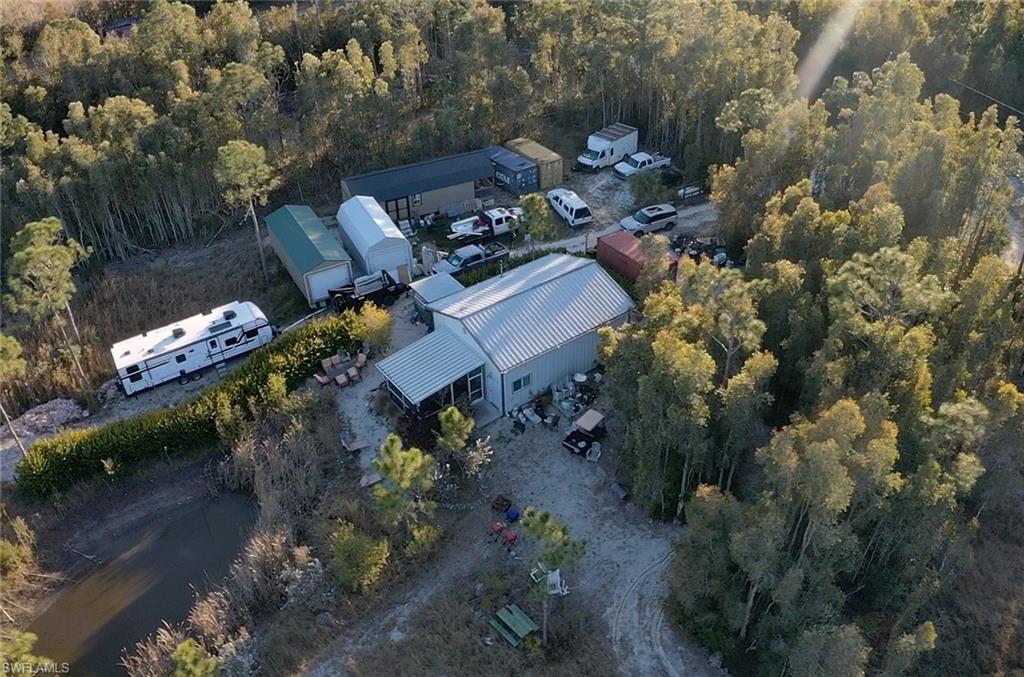 Aerial view of property and surrounding area with a heavily wooded area