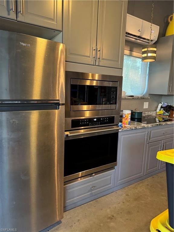 Kitchen featuring stainless steel fridge, microwave, oven. light stone counters, and gray cabinetry