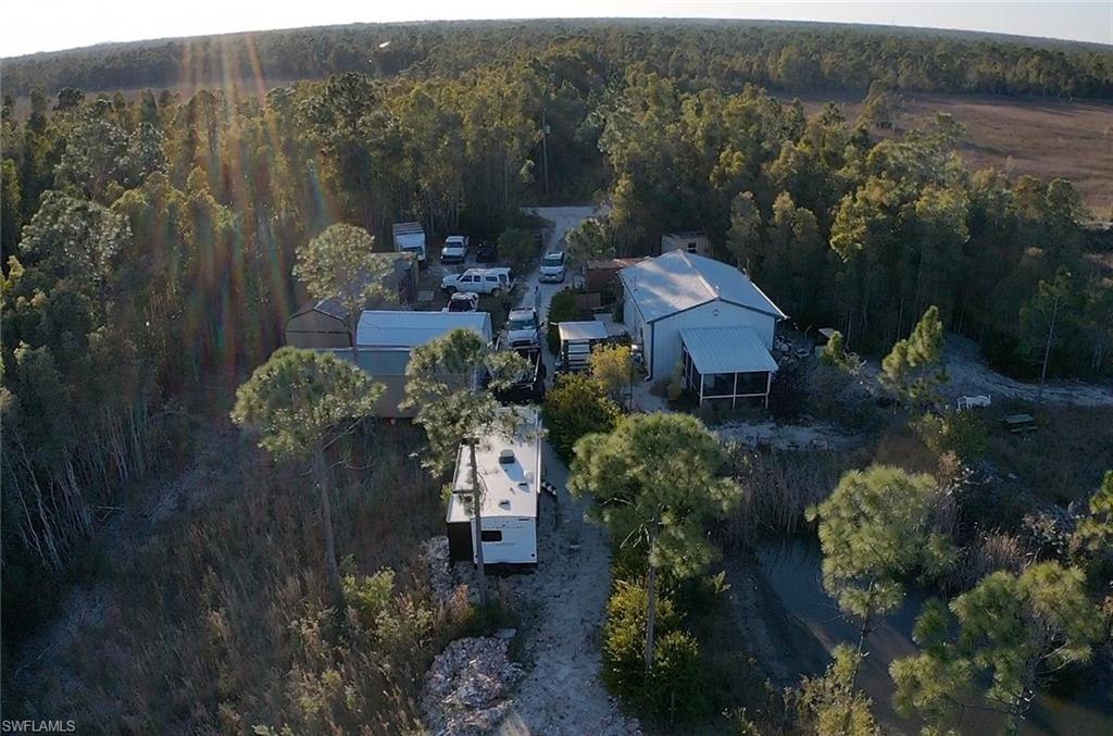 Aerial view of property and surrounding area with a heavily wooded area