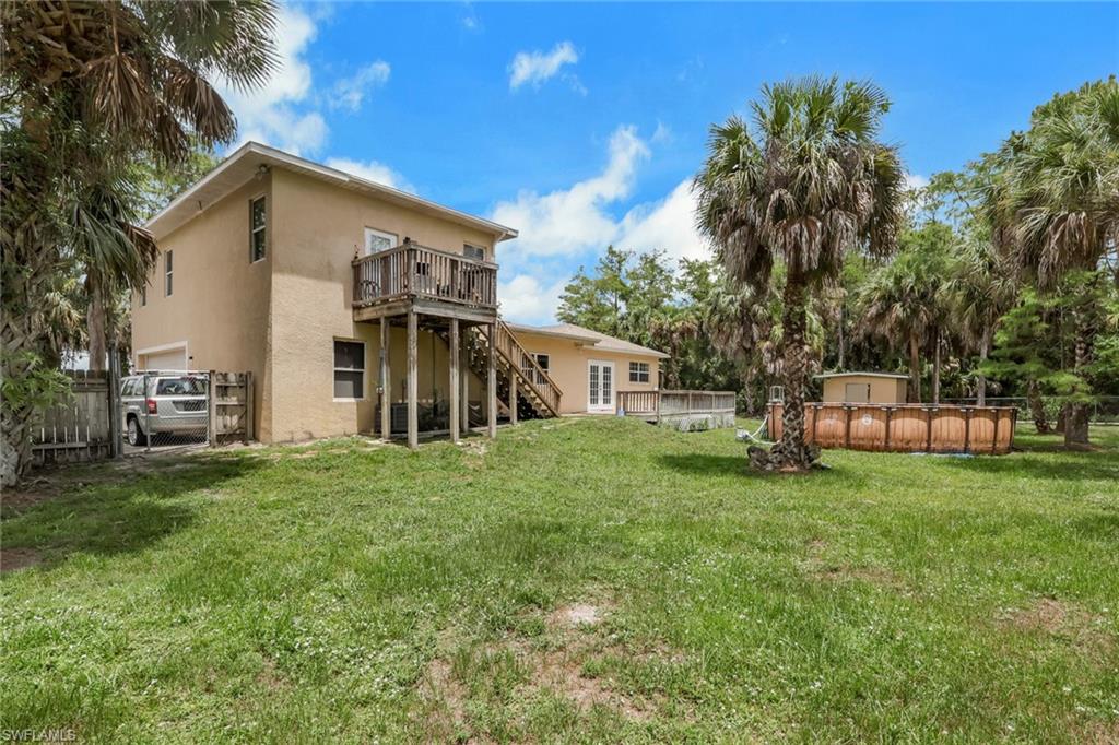 Expansive exterior featuring a stucco finish, two-story construction, and a raised wooden deck with staircase