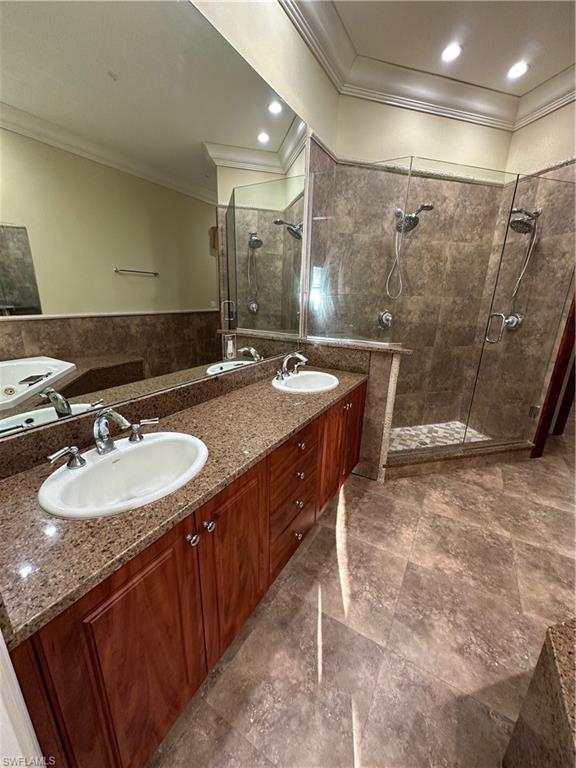 Spacious bathroom featuring a dual vanity with granite countertops, rich wood cabinetry, and chrome fixtures