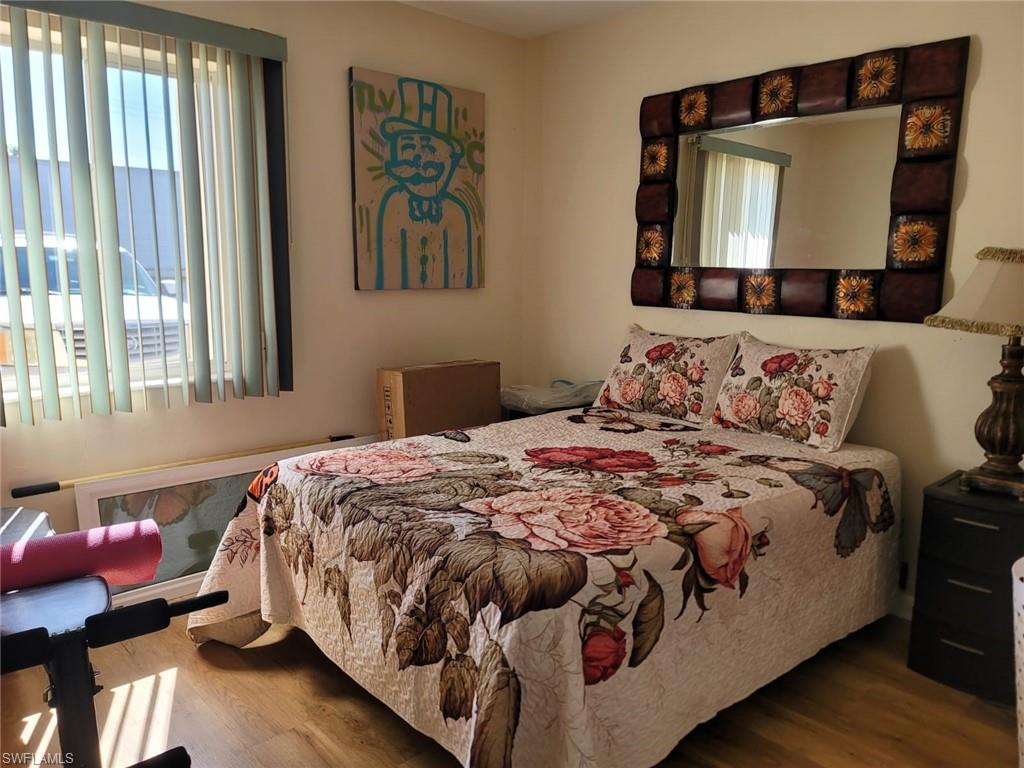 Bedroom with multiple windows and wood finished floors