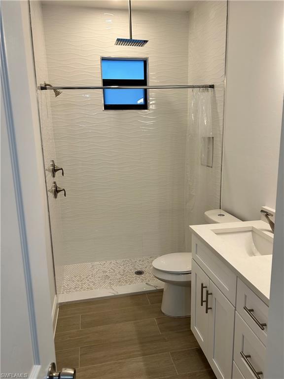 Bathroom with vanity, toilet, and curtained shower