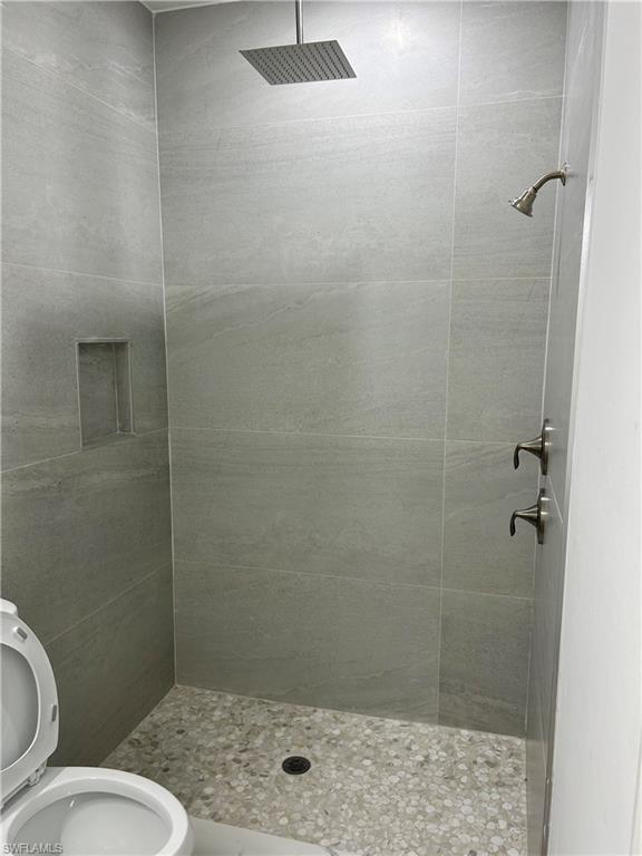 Bathroom with tiled shower and toilet